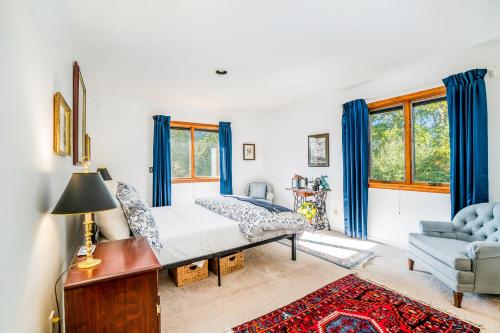 a bedroom with a bed with blue curtains and a couch at Hidden Gem in Arcadia