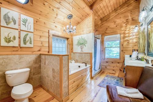y baño de madera con aseo, bañera y lavamanos. en Carolina Mountain Retreat, en Shumont