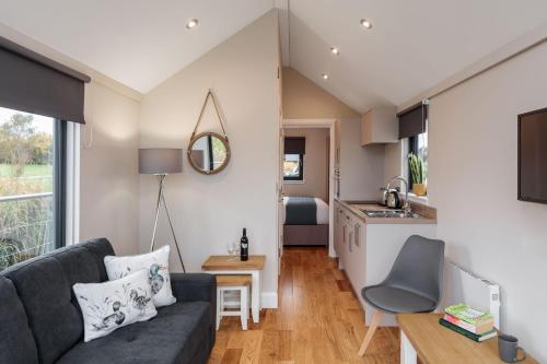 a living room with a couch and a kitchen at Sanderling in Tattenhall