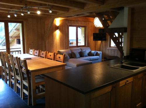 a kitchen and living room with a table and a couch at Chalet Narcisse in Sixt