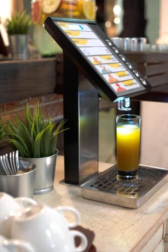 a glass of orange juice sitting on a table at Estilo Fashion Hotel Budapest in Budapest