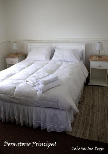 a white bed with white sheets and pillows on it at Cabañas Inadeqin in Ensenada