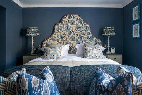 um quarto com uma cama grande e paredes azuis em The Headland Hotel and Spa em Newquay