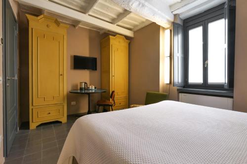 a bedroom with a bed and a table and a tv at Maison Borella in Milan