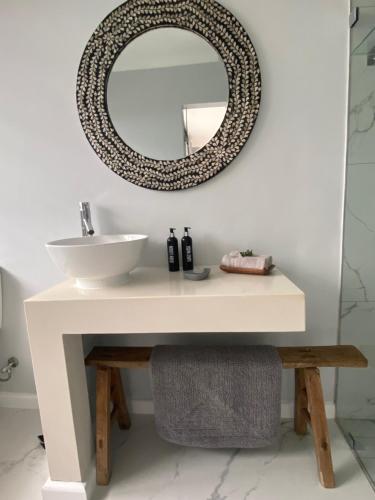 a bathroom with a sink and a mirror on the wall at Mes Amis Beach Guest House in Wilderness