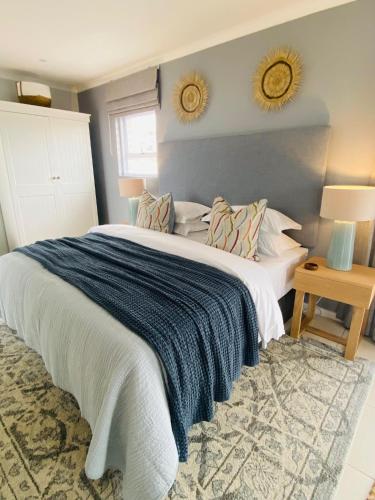 a bedroom with a large bed and two mirrors on the wall at Mes Amis Beach Guest House in Wilderness
