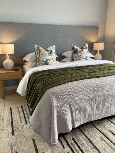 a bedroom with a large bed with two pillows at Mes Amis Beach Guest House in Wilderness