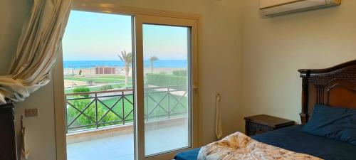 a bedroom with a bed and a view of the ocean at Villa at Piacera Resort-seaview in Ain Sokhna