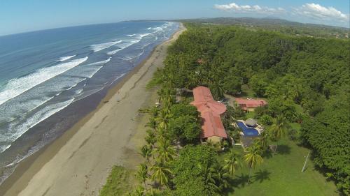 an aerial view of a house on the beach at Hotel Delfin Playa Bejuco in Esterillos Este