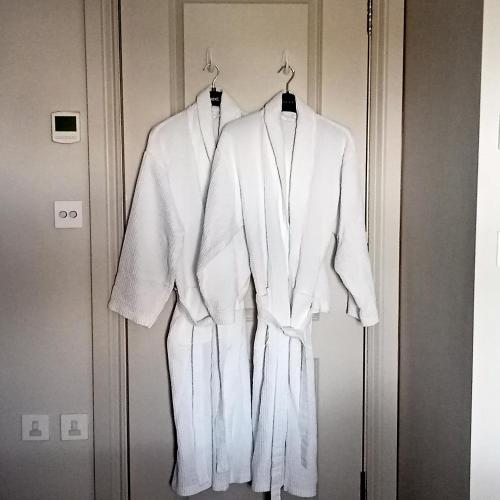 two white robes are hanging on a door at Glorious Duplex Holiday Apartment By The Sea in Bognor Regis