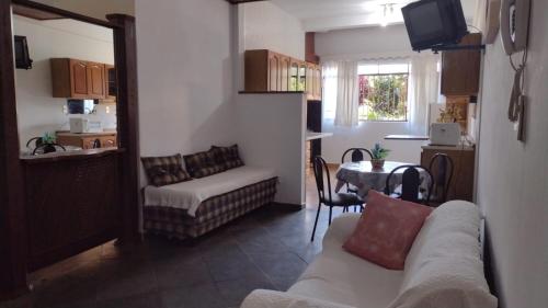 un salon avec un canapé et une table dans l'établissement Apartamento próximo aos principais pontos turísticos, à Águas de Lindóia