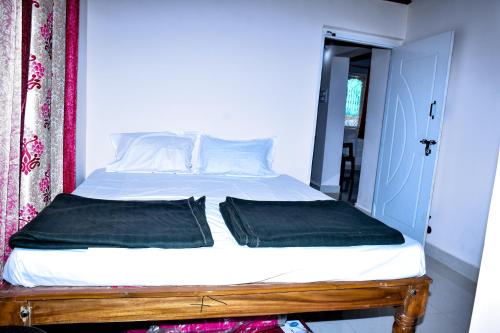 a bed with two pillows on it in a room at Immanamane Homestay in Chikmagalūr