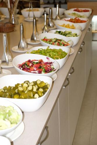 a buffet line with bowls of different types of food at Fllad Resort & SPA Durres in Golem