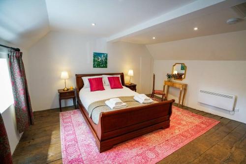 una camera da letto con un letto con cuscini rossi e un tappeto rosa di Number Five in Earl Soham Suffolk 