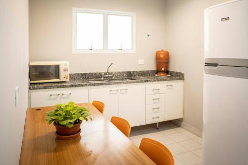 a kitchen with a wooden table and a sink at Casa Ecotrips Barra Funda - Hostel in São Paulo
