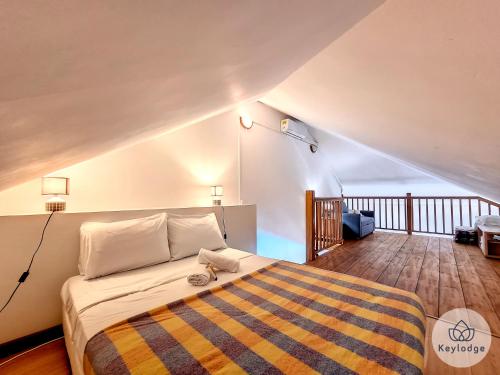 a bedroom with a bed with a striped blanket at Cumin - Studio duplex avec accès piscine à St-Gilles in Saint-Gilles les Bains