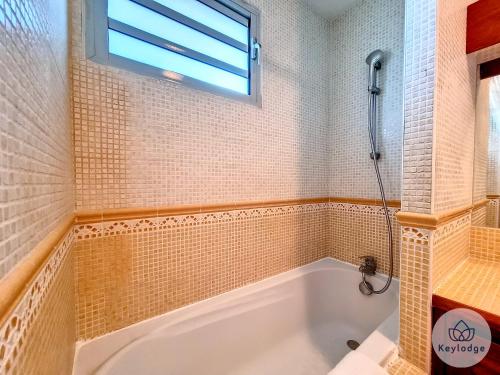 a bathroom with a bath tub and a window at Cumin - Studio duplex avec accès piscine à St-Gilles in Saint-Gilles les Bains