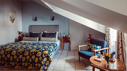 een slaapkamer met een bed en een blauwe bank bij Maison Saintonge in Parijs