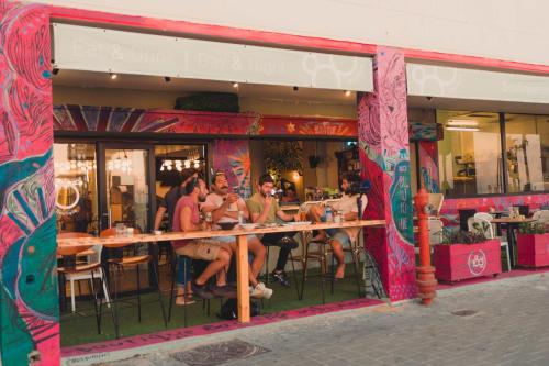 un grupo de personas sentadas fuera de un restaurante en 180 Boutique Hostel, en Tel Aviv