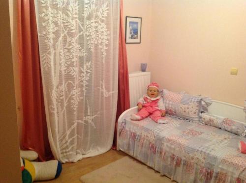 a baby sitting on a bed in a bedroom at Villa Kallia's in Vília