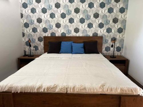 ein Schlafzimmer mit einem großen Bett mit blauen Kissen in der Unterkunft Apartments in Balatonlelle 43116 in Balatonlelle