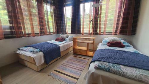 a bedroom with two beds and a table and a window at Holiday home in Szantod - Balaton 43129 in Szántód