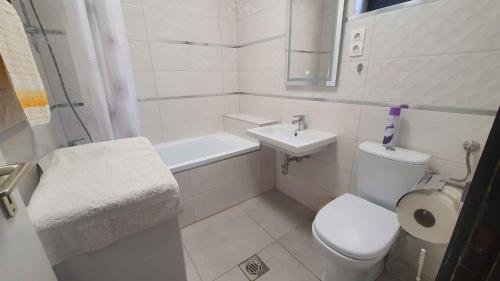 a white bathroom with a toilet and a sink at Holiday home in Szantod - Balaton 43129 in Szántód