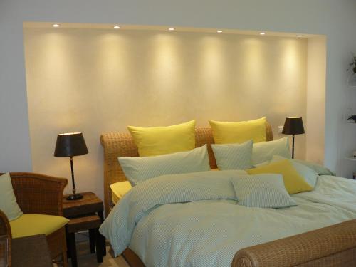 1 dormitorio con 1 cama grande con almohadas amarillas en Gästehaus Ina-Maria, Apartments, en Obernhof