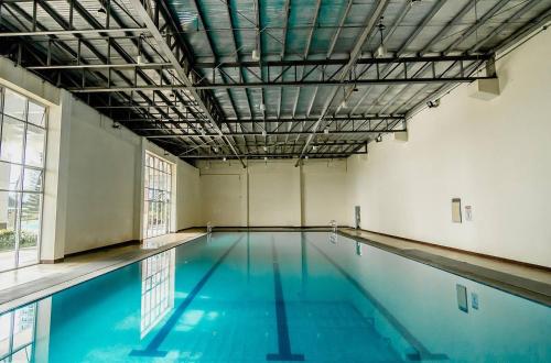 uma piscina interior com água azul num edifício em Panoramic View of Taal 1727 SMDC with wifi and free Indoor parking em Tagaytay