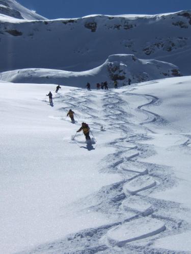 a group of people skiing down a snow covered slope at Posthotel Rössli in Gstaad