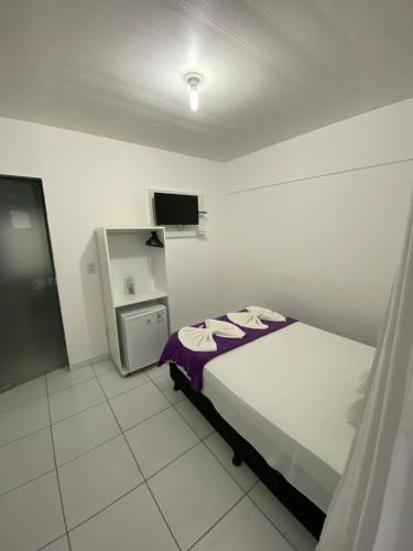 a bedroom with a bed and a tv in it at Pousada Vela Mar in Maragogi