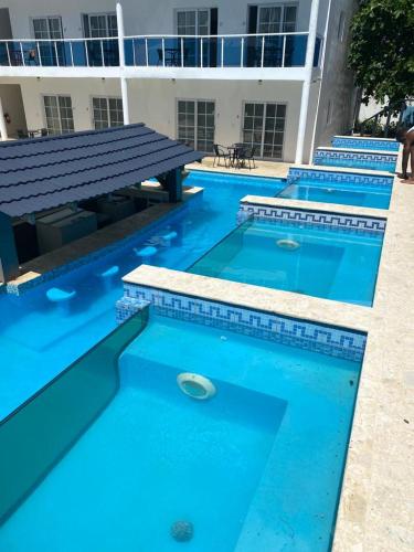 a row of blue swimming pools in front of a building at El Cabarete Spa Resort all-Inclusive in Cabarete