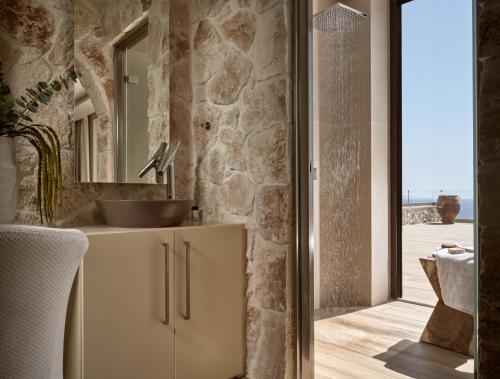 bagno con lavandino e specchio di White Springs Retreat a Orthoniaí
