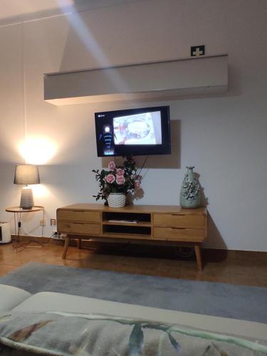 a living room with a tv on a wall at Quina'sHouse in Rossio ao Sul do Tejo