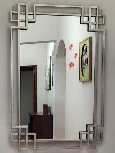 a large mirror with a metal frame on a wall at Quina'sHouse in Rossio ao Sul do Tejo