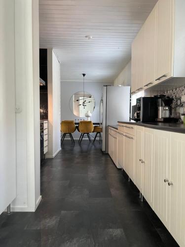 a kitchen with a white refrigerator and a table at Omakotitalo rauhallisella sijainnilla lähellä keskustaa Maksuton pysäköinti ja puusauna in Hämeenlinna