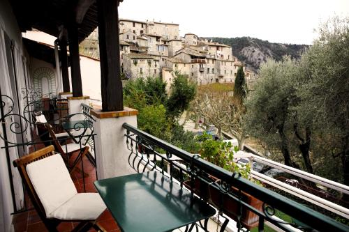 a balcony with chairs and a view of a city at Auberge De La Madone in Peillon