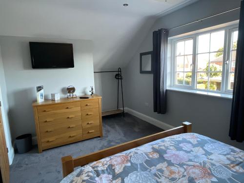 a bedroom with a bed and a tv and a dresser at The Up And Over in Northallerton