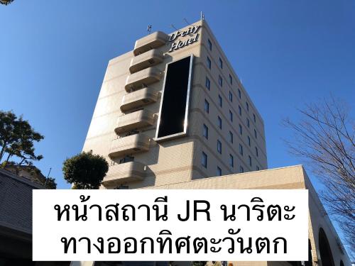 a tall building with a sign in front of it at Narita U-City Hotel in Narita