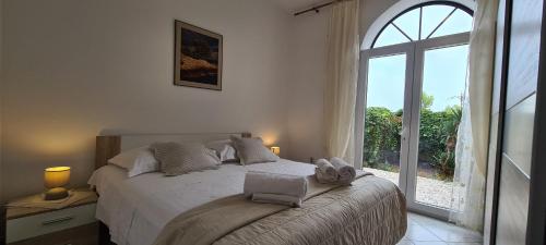 sypialnia z łóżkiem i dużym oknem w obiekcie Apartment Nikola w mieście Jelsa