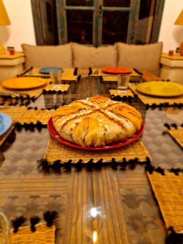 a table with a pie on top of it at Villa Nouran - Chambre Hôte in Ghazoua