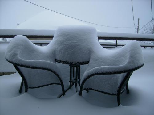 two chairs covered in snow on a balcony at Erasmion in Áno Dholianá