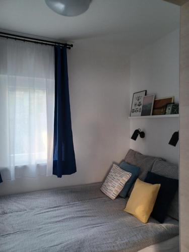a bedroom with a bed and a blue curtain at LILIOM Apartment with FREE PARKING space in Budapest