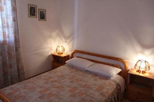 a bedroom with a bed and two lamps on two tables at Circe Pansion in Lixouri