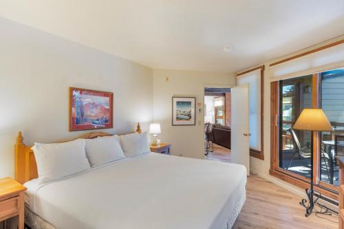 a bedroom with a white bed and a window at Lodge at Steamboat F103 in Steamboat Springs