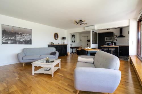 un salon avec deux canapés et une table dans l'établissement Les Terrasses de la Vallée, à Champs-sur-Marne