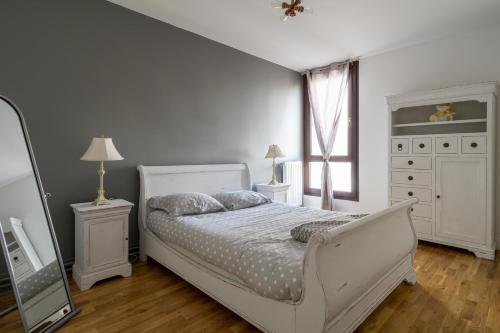 a bedroom with a white bed and a mirror at Les Terrasses de la Vallée in Champs-Sur-Marne