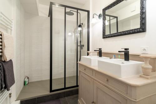 a bathroom with two sinks and a shower at Les Terrasses de la Vallée in Champs-Sur-Marne