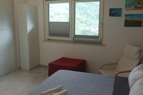 a room with a bed and a chair and a window at Faber B&B - Riserva Naturale Zompo lo Schioppo in Morino