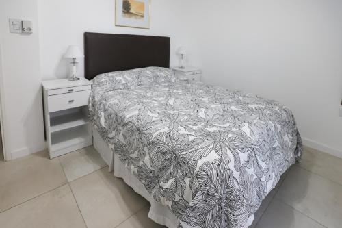 a bedroom with a bed with a black and white blanket at GARAY 29- Depto un dormitorio in Santa Fe